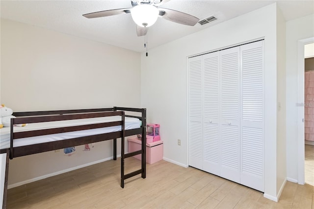 bedroom featuring light hardwood / wood-style flooring, a closet, and ceiling fan