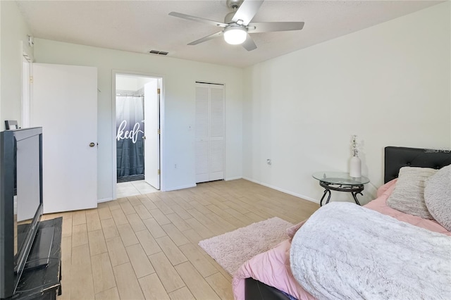 bedroom with ceiling fan, light hardwood / wood-style flooring, and connected bathroom