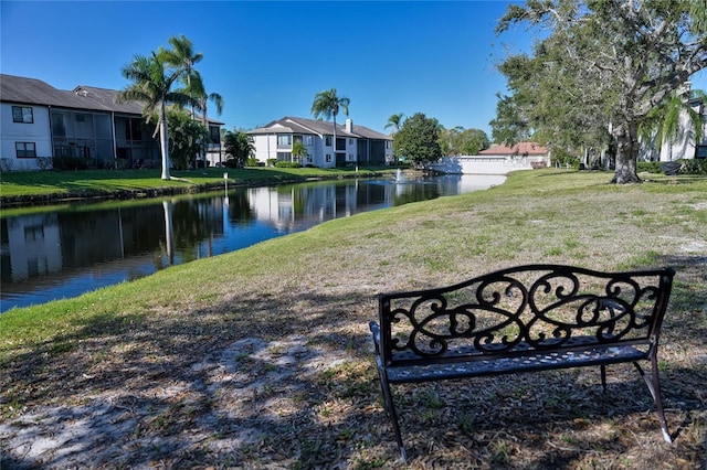 view of home's community with a water view and a yard