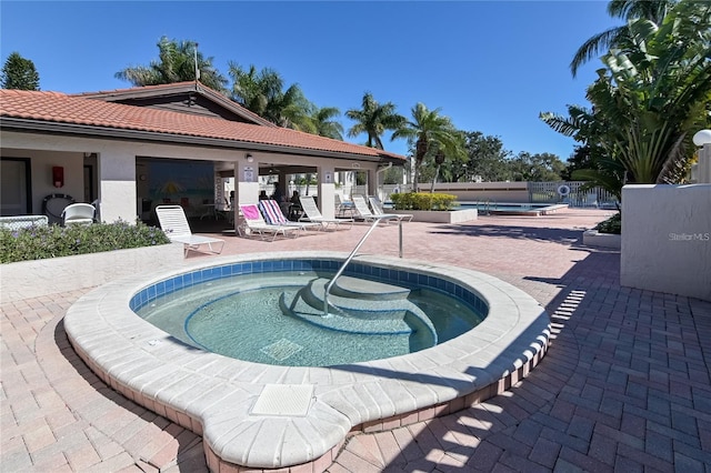 view of swimming pool with a patio and a hot tub