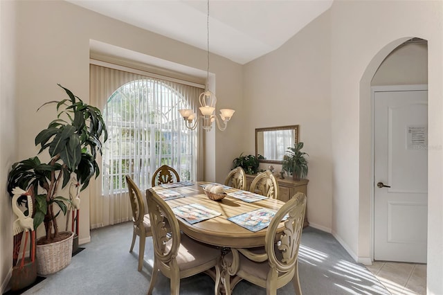 carpeted dining room featuring a chandelier and lofted ceiling