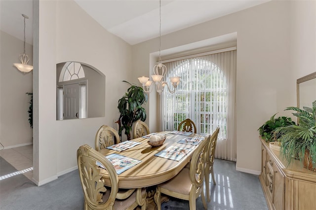 dining room with carpet, lofted ceiling, and a notable chandelier