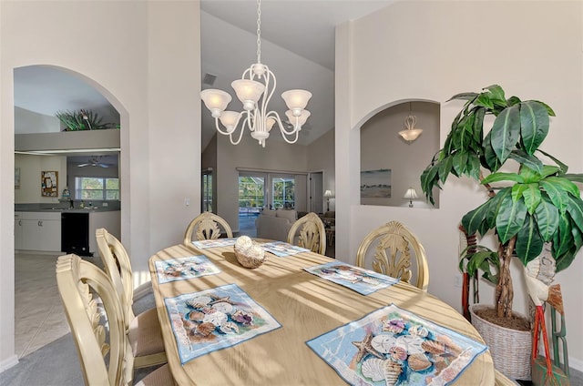 tiled dining space featuring a notable chandelier and high vaulted ceiling