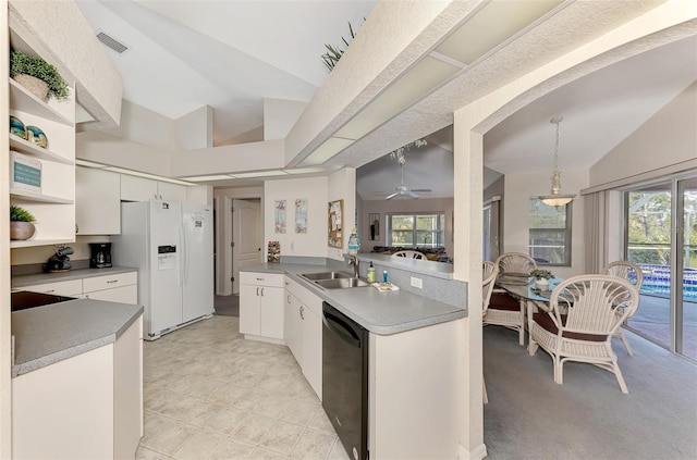 kitchen featuring sink, white refrigerator with ice dispenser, black dishwasher, white cabinetry, and lofted ceiling