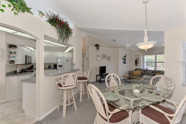 tiled dining area featuring ceiling fan and vaulted ceiling