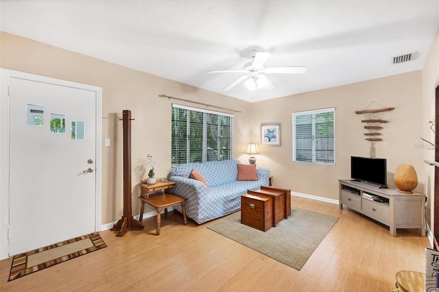 living room with light hardwood / wood-style floors and ceiling fan