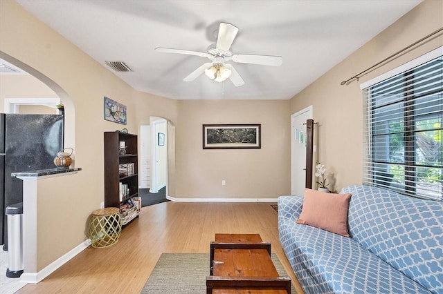 living room with light hardwood / wood-style floors and ceiling fan