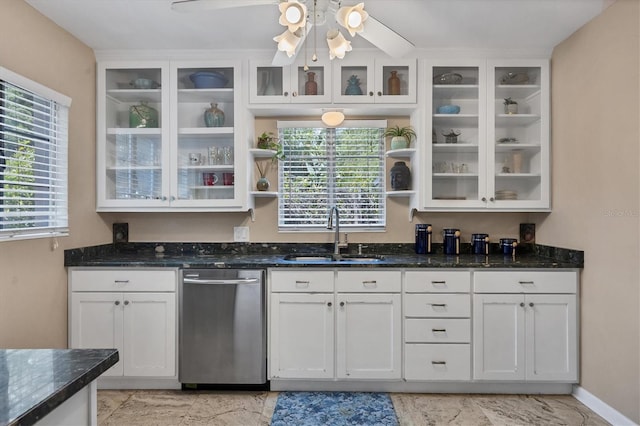 kitchen with white cabinets, sink, stainless steel dishwasher, ceiling fan, and dark stone countertops