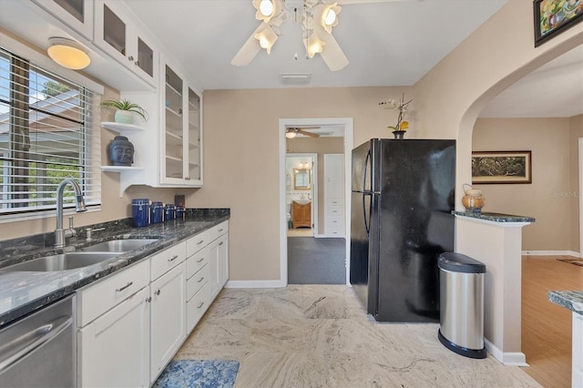 kitchen featuring dark stone counters, black refrigerator, sink, stainless steel dishwasher, and white cabinetry