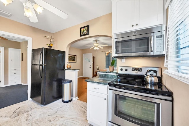 839 40th St, Sarasota, FL 34234 - kitchen with stainless steel appliances, ceiling fan, arched walkways, and white cabinets
