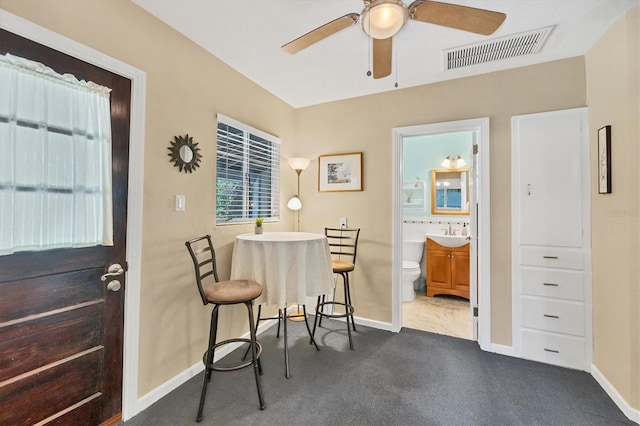 carpeted dining room featuring ceiling fan and sink