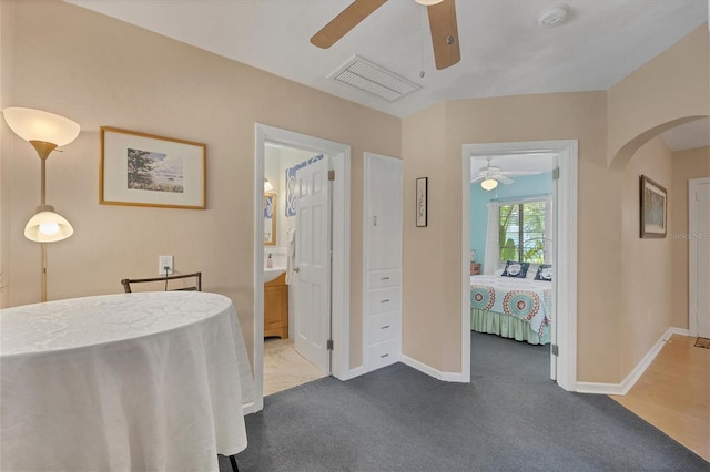 bedroom featuring carpet flooring, ensuite bathroom, and ceiling fan