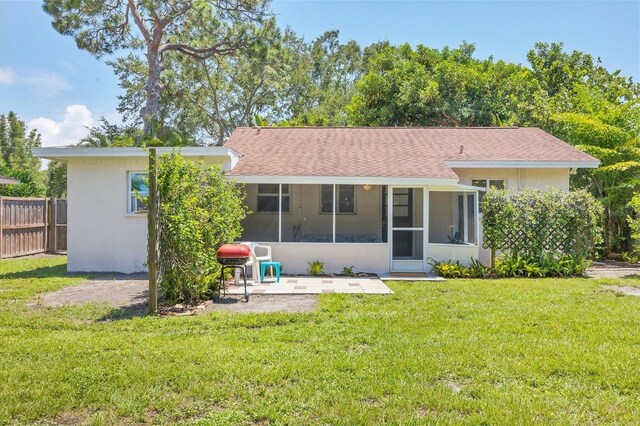839 40th St, Sarasota, FL 34234 - back of property featuring a sunroom, a patio, stucco siding, and a shingled roof