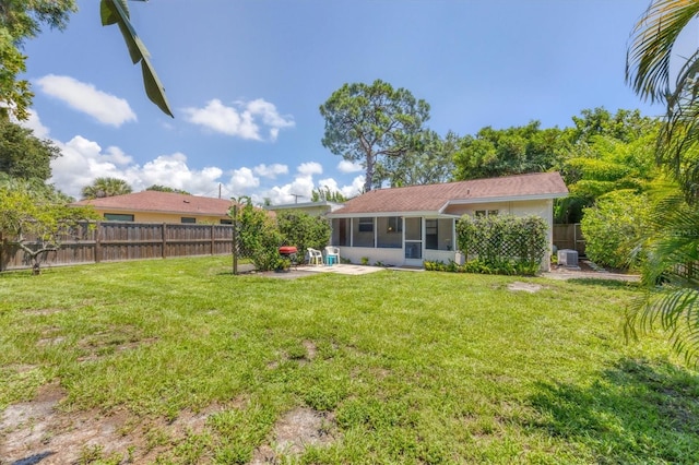 back of property with a yard and a sunroom