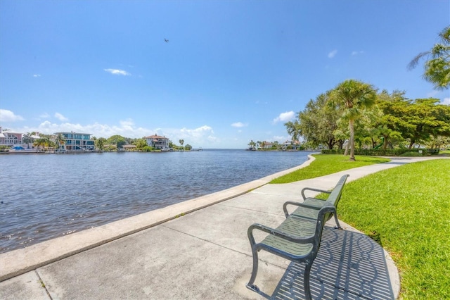 view of property's community featuring a lawn and a water view