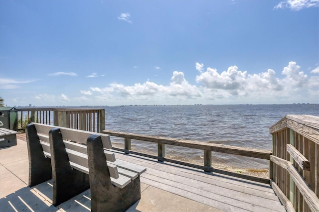 view of dock featuring a beach view and a water view