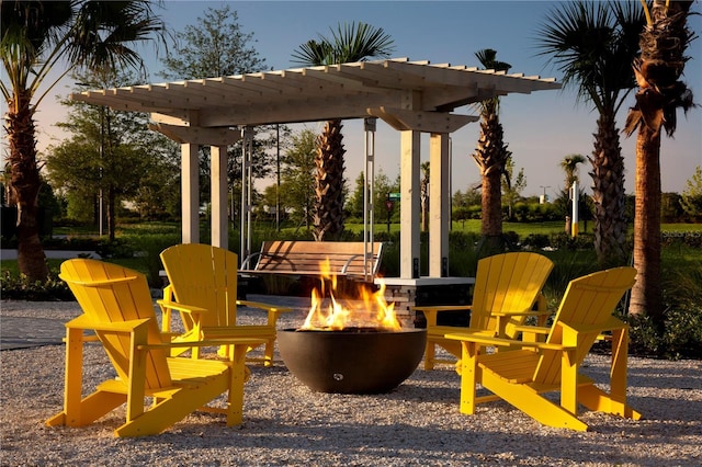 patio terrace at dusk with an outdoor fire pit and a pergola