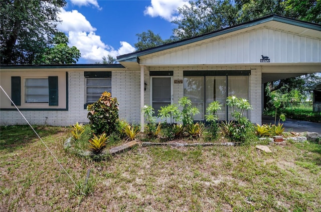 ranch-style house with a carport and a front yard