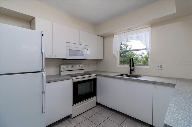 kitchen with white cabinetry, white appliances, sink, and light tile patterned floors