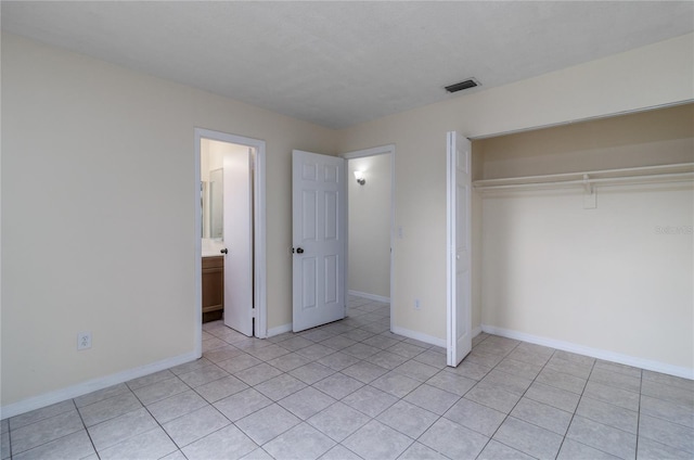 unfurnished bedroom with light tile patterned floors and a closet