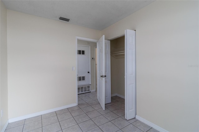 unfurnished bedroom featuring a closet and light tile patterned floors