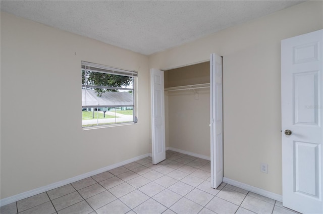 unfurnished bedroom featuring light tile patterned floors, a closet, and a textured ceiling