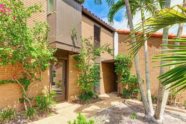 view of exterior entry with brick siding