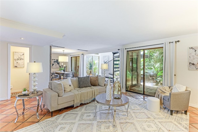 living area with ornamental molding, a healthy amount of sunlight, baseboards, and tile patterned floors