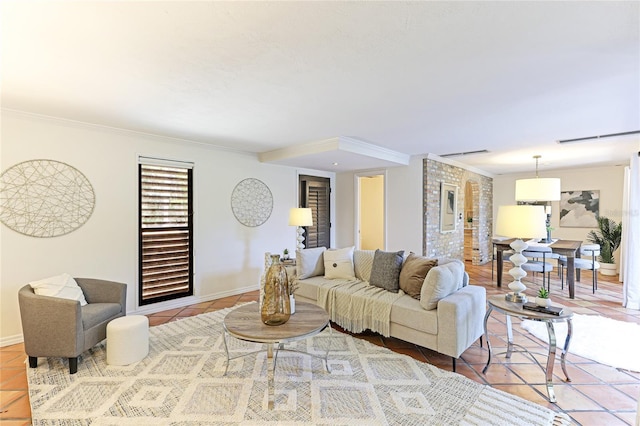 living room featuring baseboards, ornamental molding, and tile patterned floors