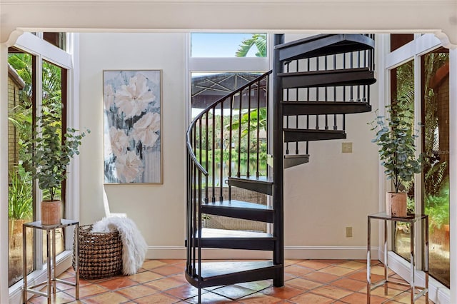 doorway to outside featuring stairs, tile patterned flooring, and baseboards