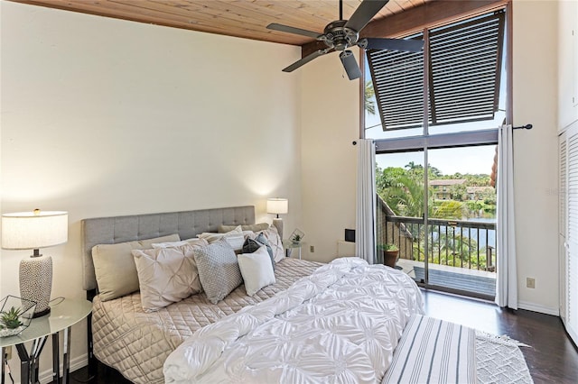 bedroom with baseboards, wooden ceiling, dark wood-type flooring, access to outside, and a high ceiling