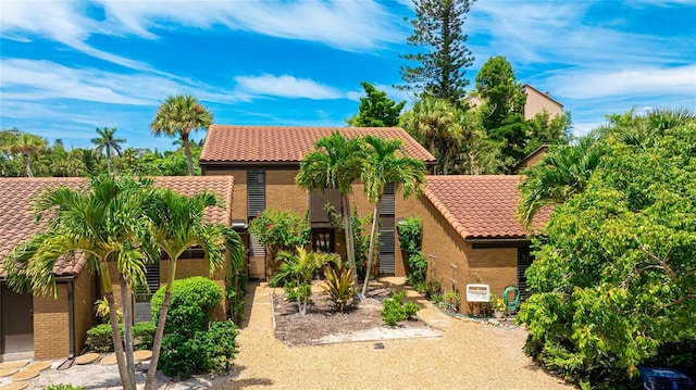 view of front of home featuring brick siding and a tile roof