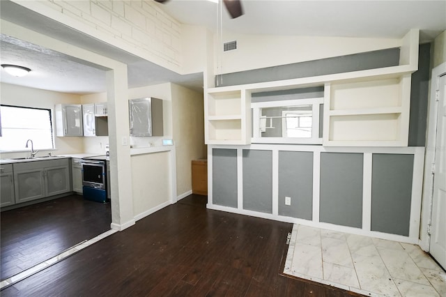 kitchen featuring range, gray cabinets, hardwood / wood-style floors, vaulted ceiling, and sink