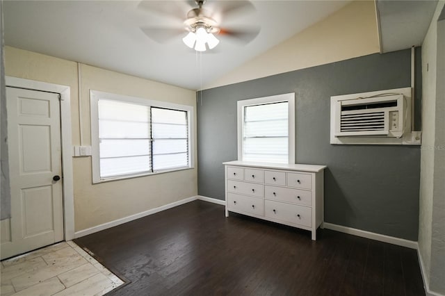 interior space featuring lofted ceiling, a wall unit AC, hardwood / wood-style floors, and ceiling fan