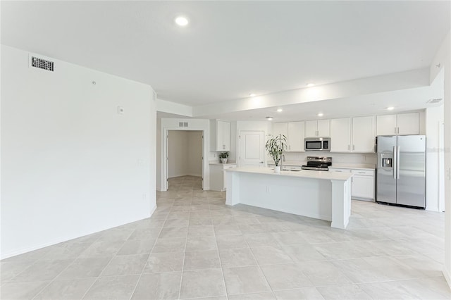 kitchen featuring stainless steel appliances, a center island with sink, and white cabinets