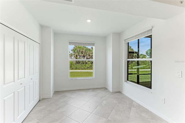 unfurnished bedroom with light tile patterned floors and a closet