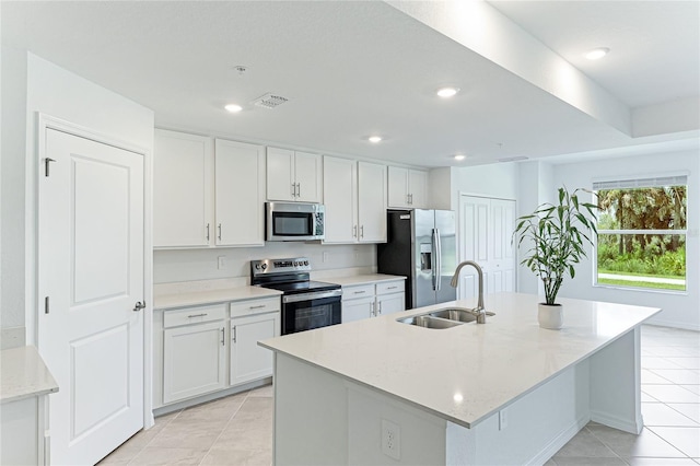 kitchen featuring appliances with stainless steel finishes, a kitchen island with sink, and white cabinets