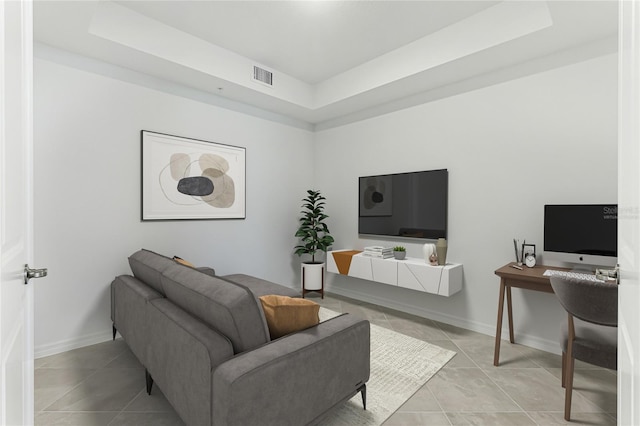 tiled living room featuring a raised ceiling