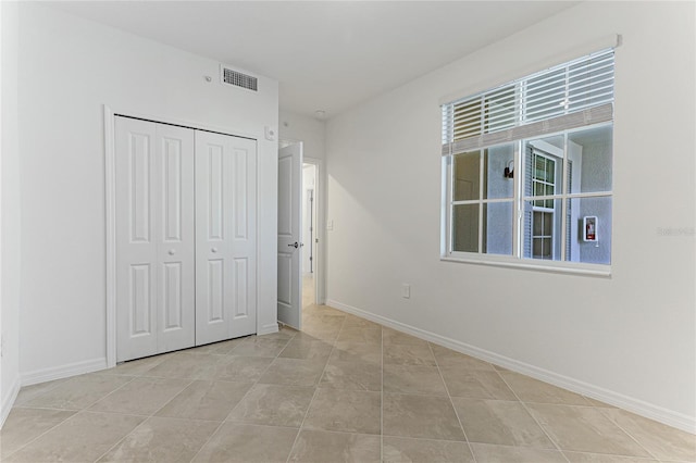 unfurnished bedroom featuring a closet and light tile patterned floors