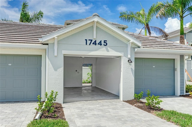 17445 Opal Sand Dr Unit 104, Venice, FL 34293 - view of front of property with a tile roof, a garage, stucco siding, and decorative driveway