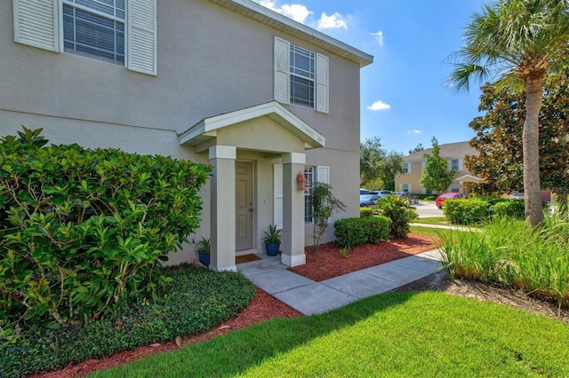 entrance to property with a lawn