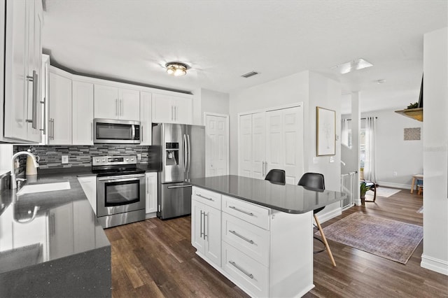 kitchen featuring sink, stainless steel appliances, dark hardwood / wood-style flooring, and white cabinetry