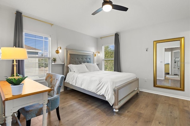 bedroom featuring ceiling fan, multiple windows, and hardwood / wood-style floors