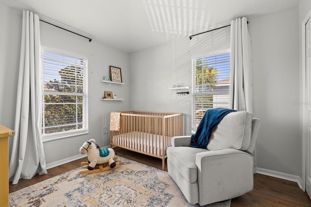 sitting room with dark wood-type flooring and plenty of natural light