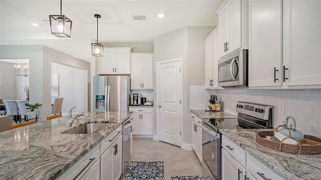 kitchen with white cabinetry, light tile patterned floors, backsplash, stainless steel appliances, and sink