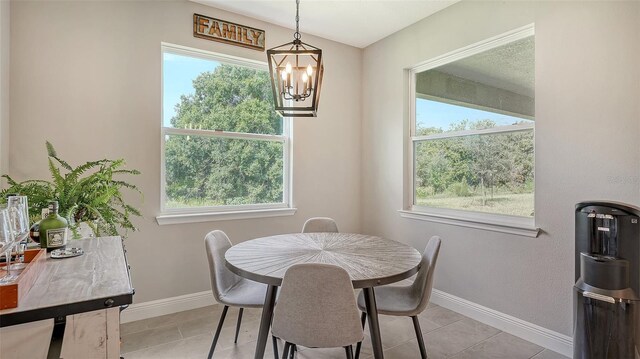 dining space featuring light tile patterned floors and an inviting chandelier