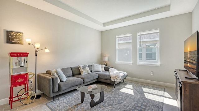 living room with light tile patterned flooring and a raised ceiling