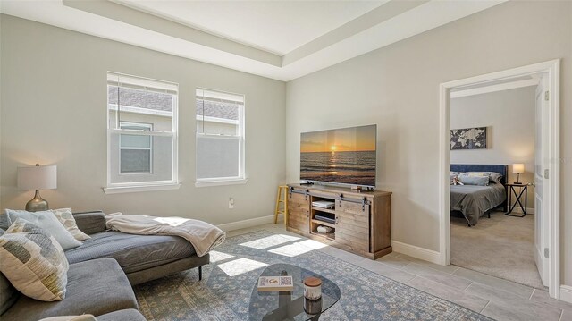 tiled living room featuring a tray ceiling