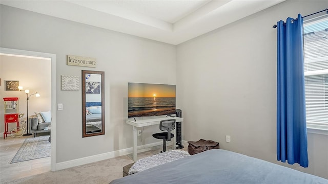 carpeted bedroom featuring a tray ceiling