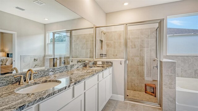 bathroom featuring double sink vanity, tile patterned flooring, and separate shower and tub